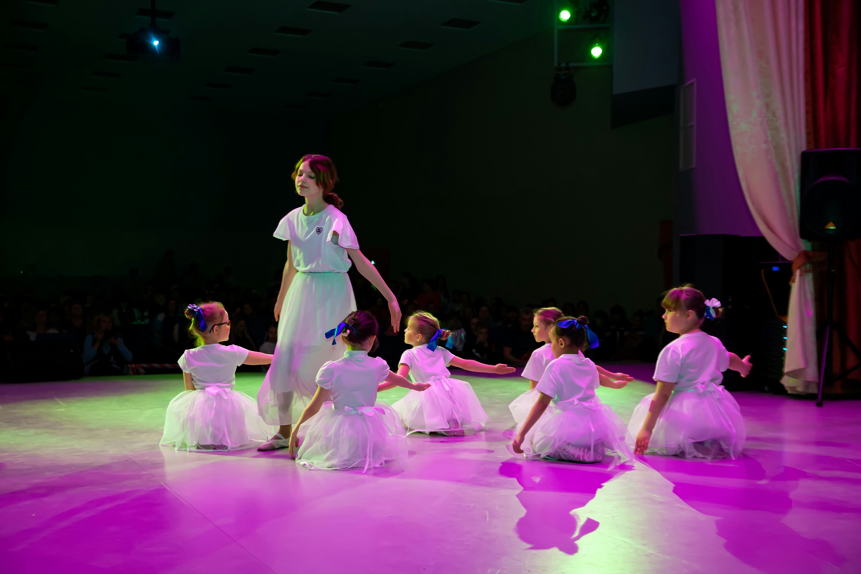 Children practicing dance steps with an instructor